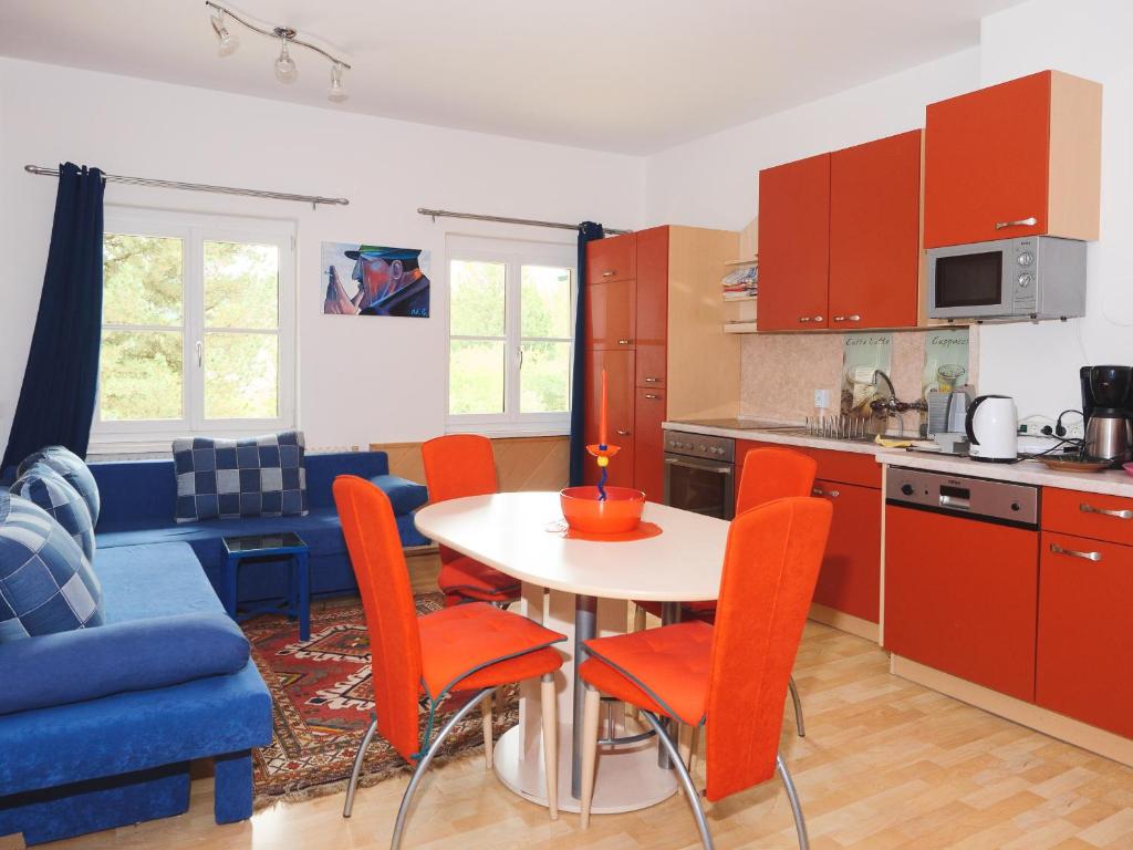 eine Küche mit orangefarbenen Stühlen und einem Tisch in der Küche in der Unterkunft Holiday Apartment Nana in Reichenfels