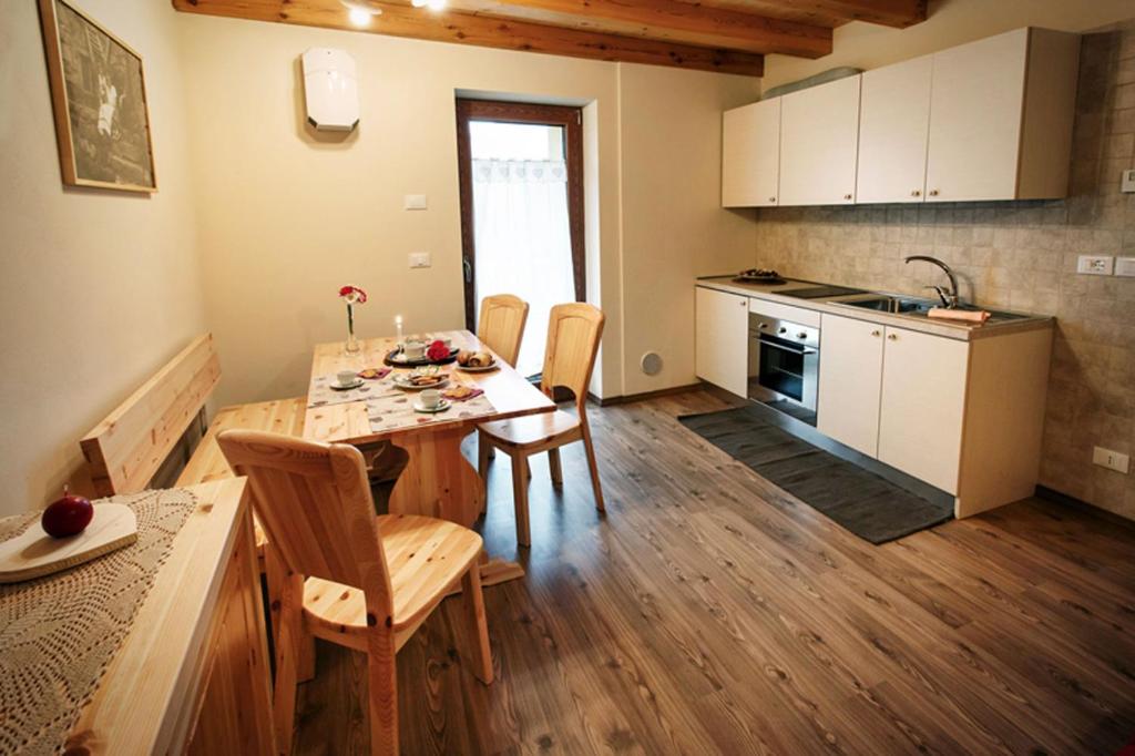 una cucina e una sala da pranzo con tavolo e sedie di La Marmote Albergo Diffuso di Paluzza San Nicolò a Paluzza