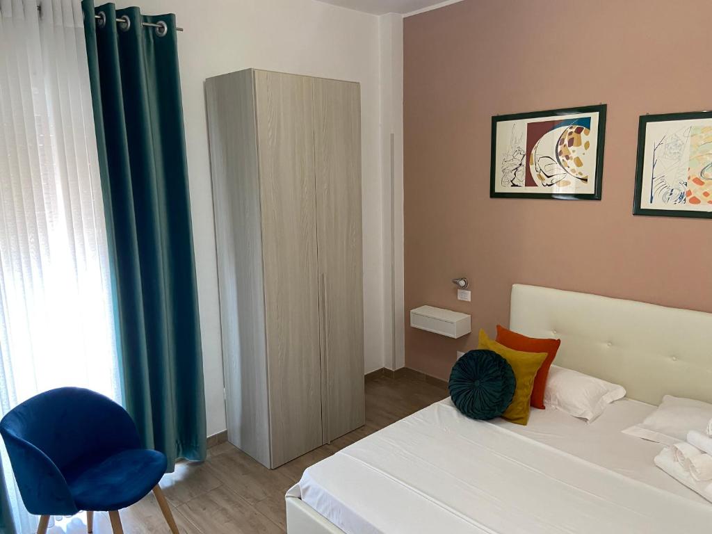 ローマにあるJuna's guest houseのベッドルーム(白いベッド1台、青い椅子付)