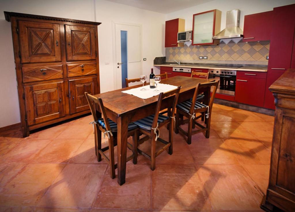 una cucina con tavolo e sedie in legno di La Marmote Albergo Diffuso di Paluzza Testeons Nord a Paluzza