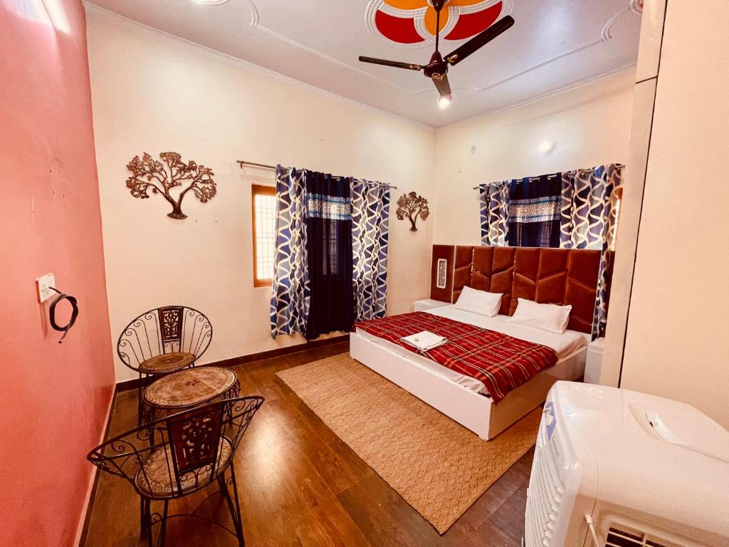 una camera con letto, tavolo e sedie di Stayble Homestay a Dehradun