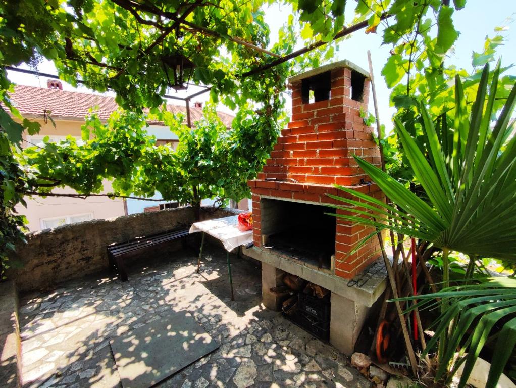 a brick oven in a garden with a bench at Apartmani David in Pula