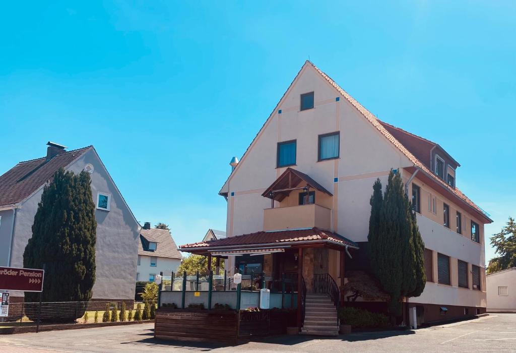 a large white building with a store in front of it at Heiligenröder Pension in Niestetal