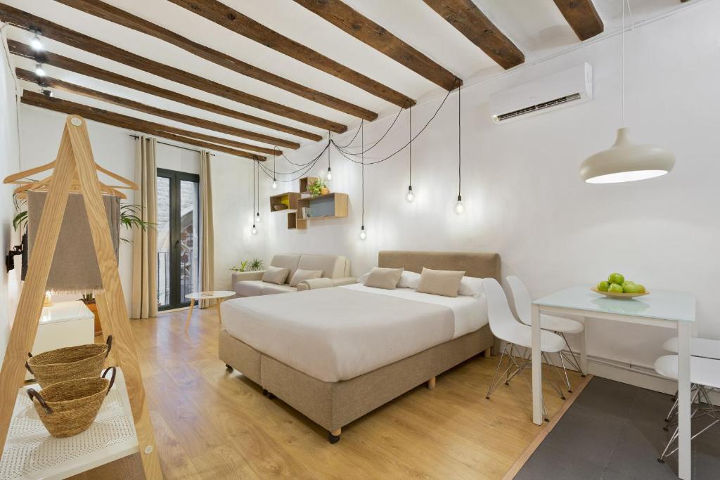 a white bedroom with a bed and a table at Ola Living Born in Barcelona