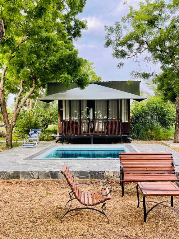 a house with a pool and a bench next to it at Kaaya Eco Resort Yala in Tissamaharama