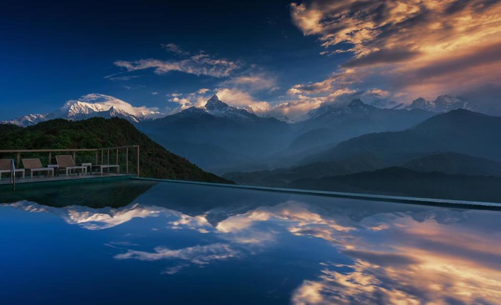 a infinity pool with a view of the mountains at Sarangkot Mountain Lodge in Pokhara