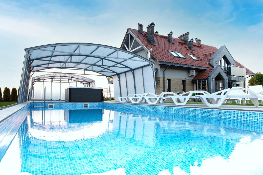 a swimming pool in front of a house at Apartamenty Mazurski Rejs in Węgorzewo