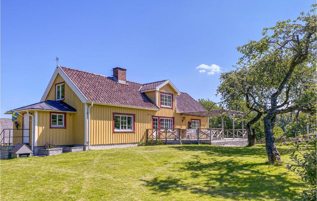 a yellow house with a yard and a tree at Beautiful Home In Varberg With Wifi And 4 Bedrooms in Varberg