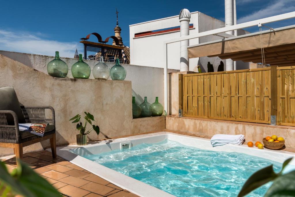 - un bain à remous dans une terrasse avec des vases sur le mur dans l'établissement Casa Sevilla 1855 Suites by Época, à Séville