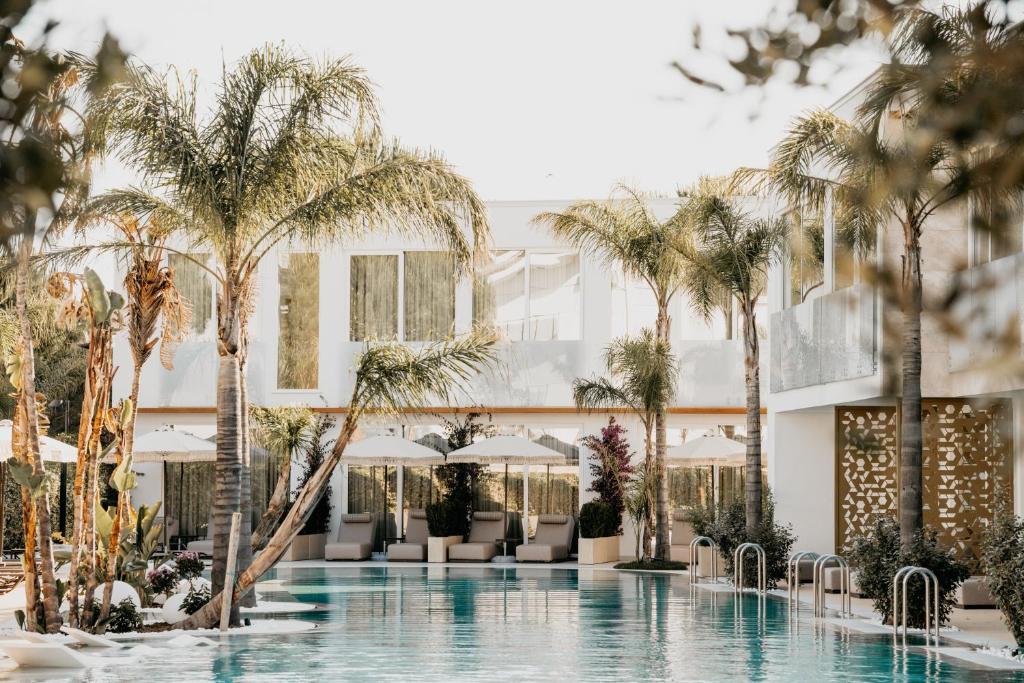 ein Hotel mit einem Pool und Palmen in der Unterkunft Elite Bay Hotel Lalez Durres in Lalëz