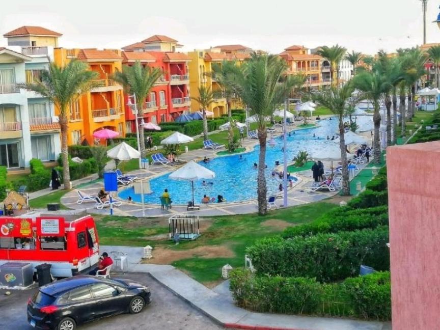a view of a resort with a pool and palm trees at GREEN PORTO Matrouh Chalets in Marsa Matruh