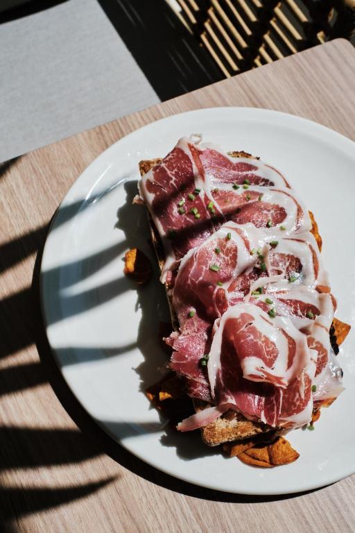 a piece of meat on a plate on a table at Helios Mallorca Hotel & Apartments in Can Pastilla