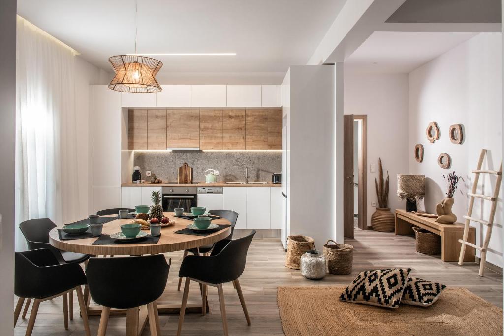 een keuken en eetkamer met een tafel en stoelen bij Khroma Luxury Suite 1 Beach front apartment in Chersonissos