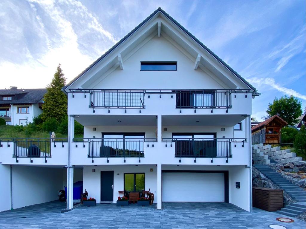 a white house with a balcony at Villa Number 8 in Feldberg