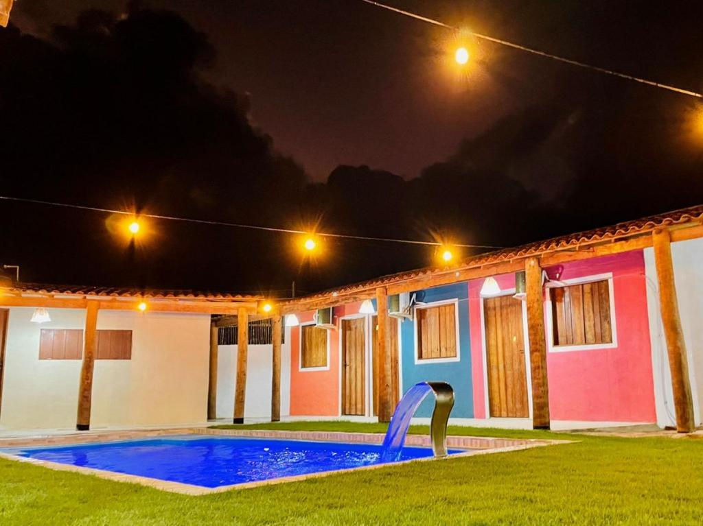 a house with a swimming pool at night at Pousada Ventos e Velas in Pôrto de Pedras