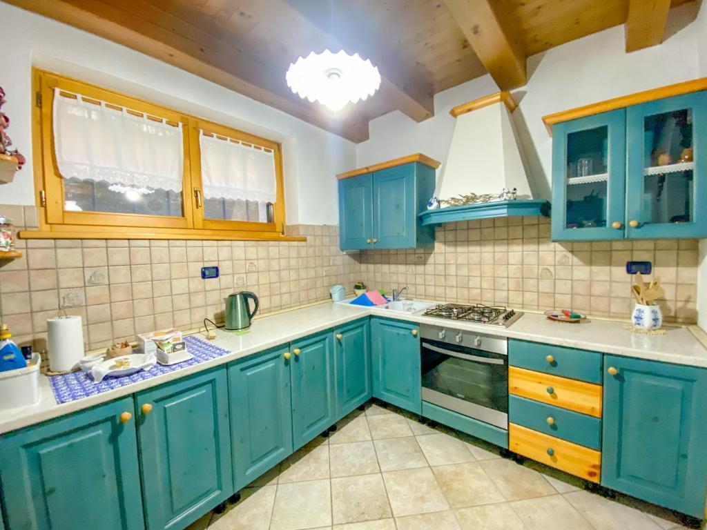 una cucina blu con banconi bianchi e armadi blu di Casa Stelin a Casso