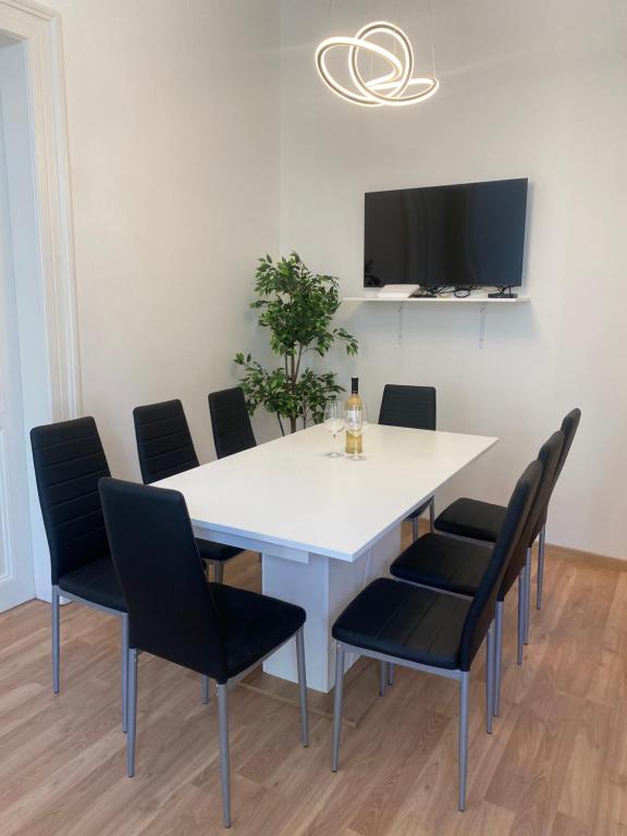 une salle à manger avec une table et des chaises blanches dans l'établissement Designed apartment next to Vaclav square with terrace and private garage, à Prague