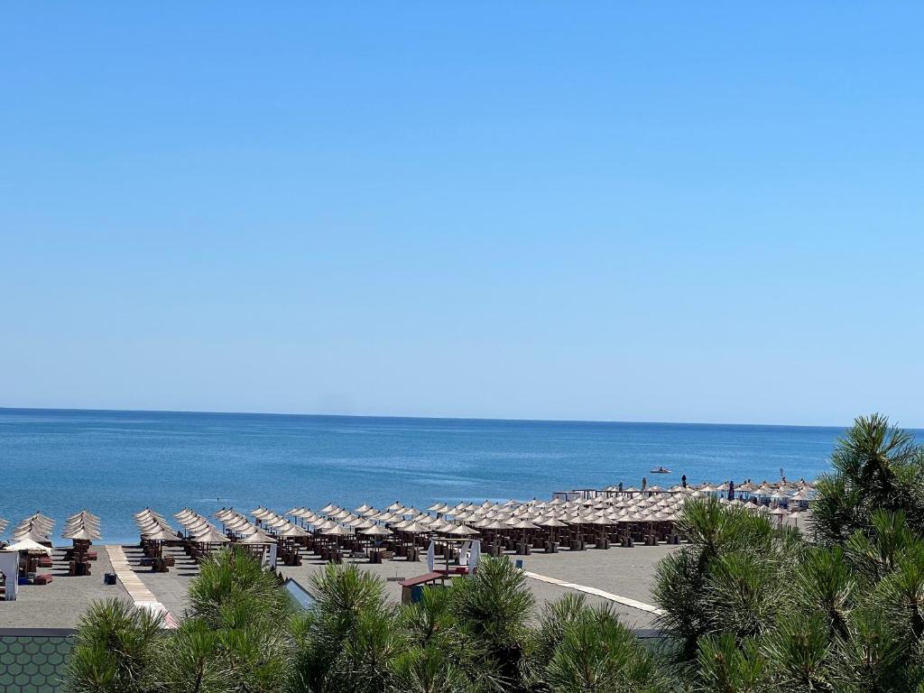 een uitzicht op een strand met parasols en de oceaan bij Bianca Apartments in Velipojë