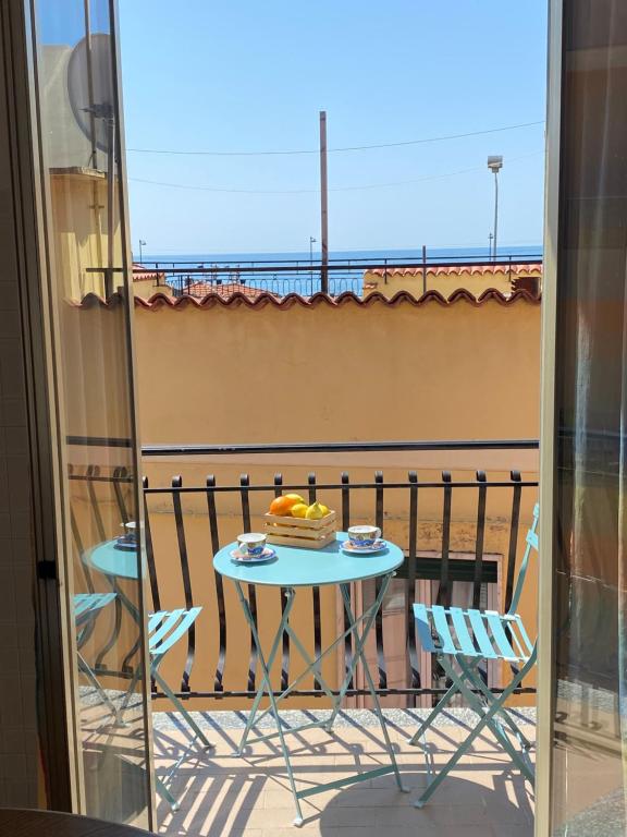 een tafel met een taart op het balkon bij Casa Enza: appartamento a un passo dal mare. in Bordighera