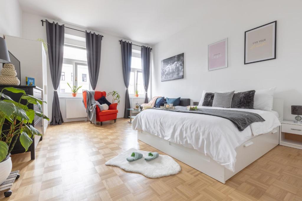 ウィーンにあるYeshello Vienna Central Station Apartmentの白いベッドルーム(大型ベッド1台、椅子付)