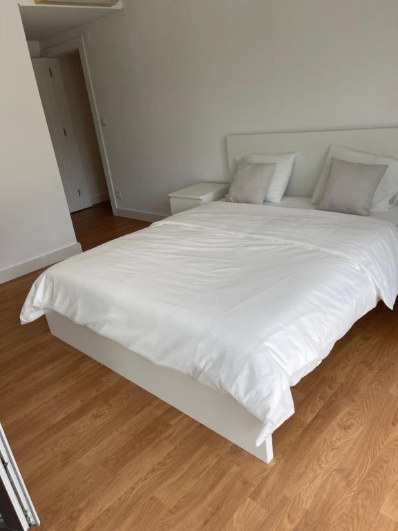 duże białe łóżko z białą pościelą i poduszkami w obiekcie 理想方向 w Lizbonie