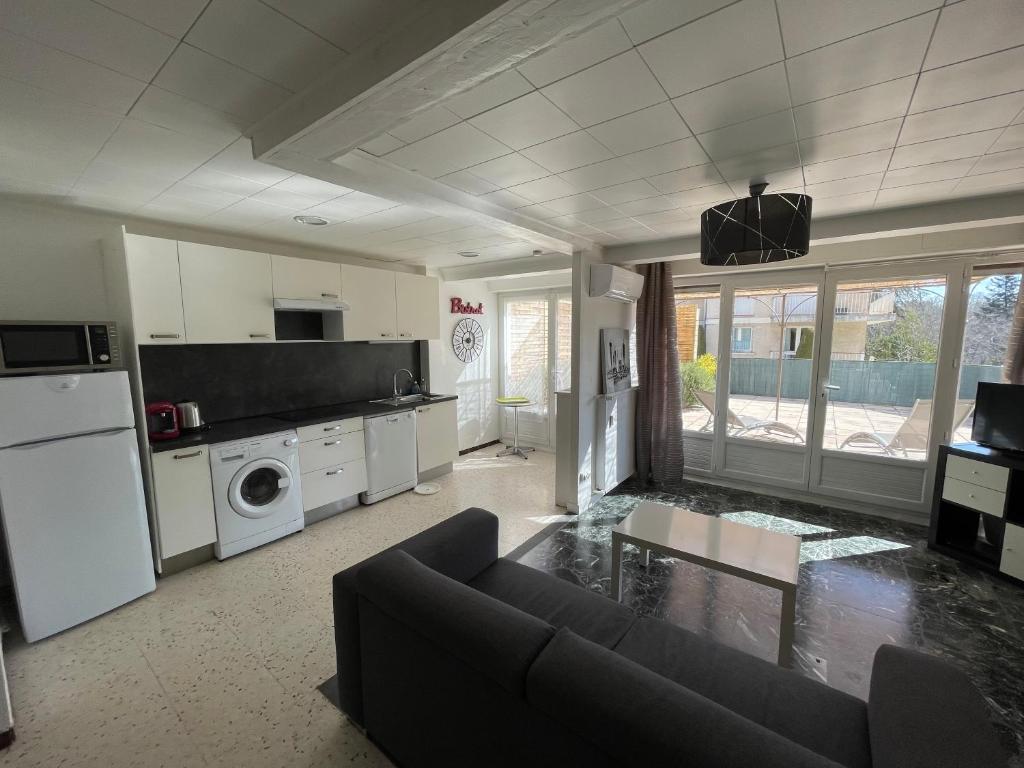 sala de estar amplia con sofá y cocina en Le Verlaine - Superbe T3 avec grande terrasse, en Gréoux-les-Bains