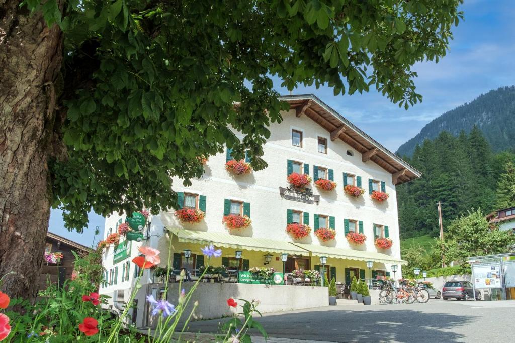 um grande edifício branco com caixas de flores em Gasthof zur Post - Hauserwirt em Sankt Jakob in Haus