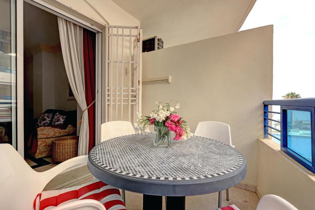 マルベーリャにあるFirst Line Beach Apartmentの花瓶付きのダイニングテーブル