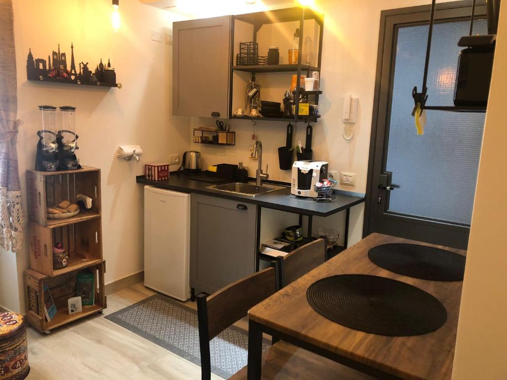 a small kitchen with a table and a sink at Snake13 in Offida