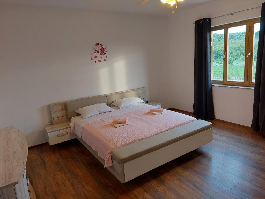 sypialnia z łóżkiem i dużym oknem w obiekcie Apartments Bakša w mieście Kanfanar