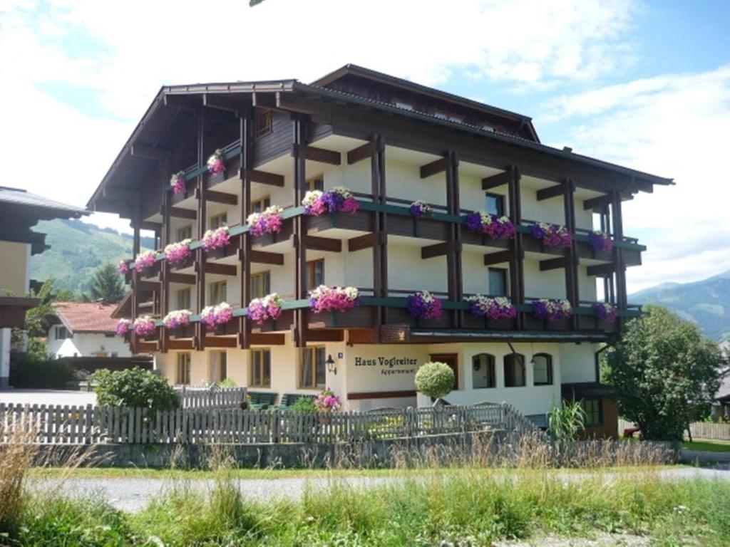 un bâtiment avec des fleurs sur son côté dans l'établissement Haus Voglreiter, à Kaprun