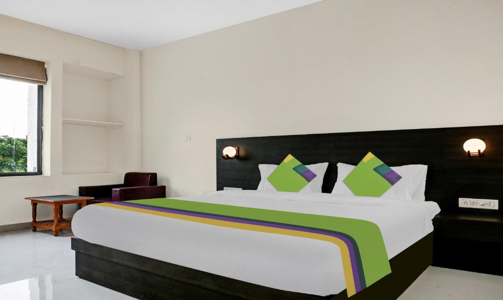 um quarto com uma grande cama branca e uma colcha de cama arco-íris em Treebo Trend Little Budhha em Varanasi