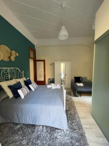 Un dormitorio con una cama azul y un sofá. en B&B ELEGANT LENA, en Salerno