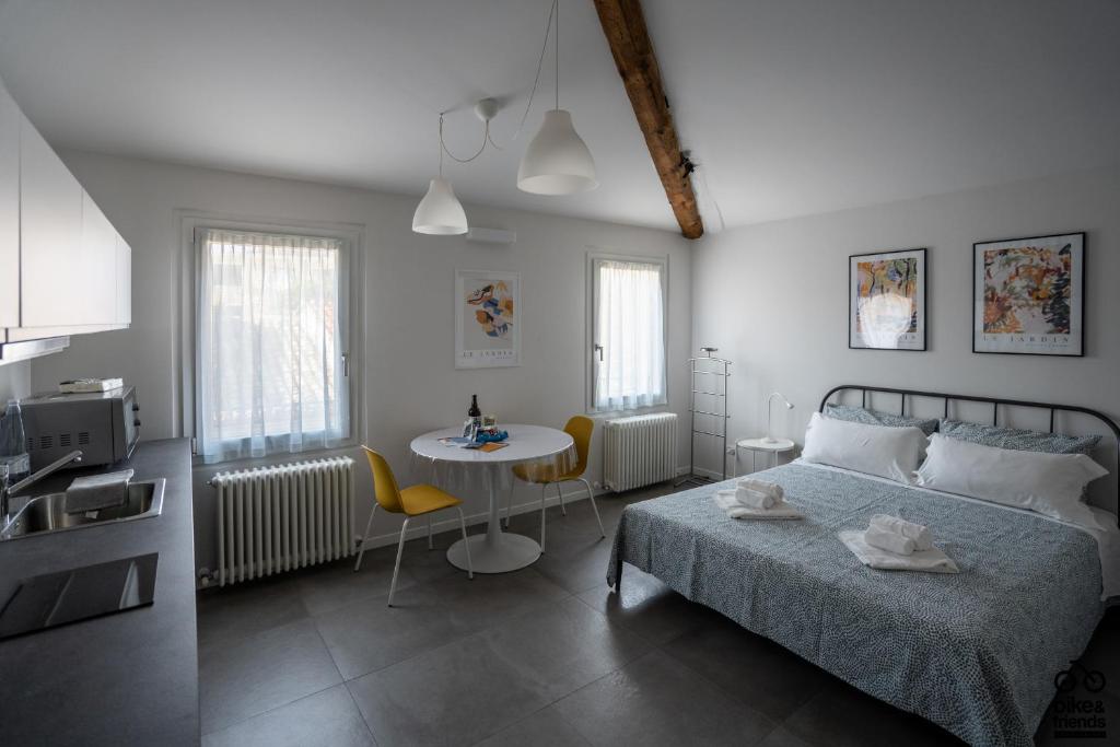 1 dormitorio con cama, mesa y cocina en MONOLOCALE LE RONDINI centralissimo en Pesaro