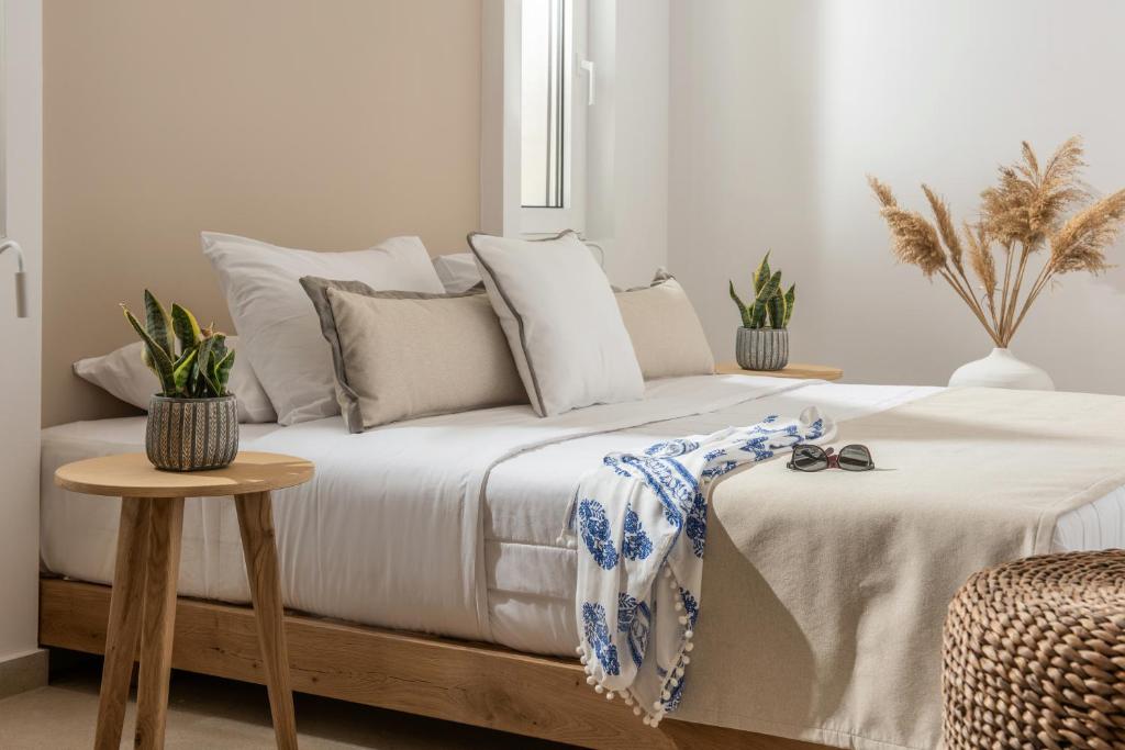 科奇諾比歌的住宿－Aether by Nymphs residence II，一间卧室配有一张带桌子和植物的床