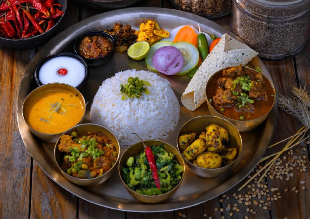 a plate of food with rice and different types of food at Sarangkot Mountain Lodge in Pokhara