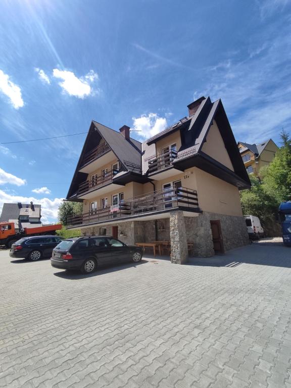 a large house with a car parked in a parking lot at Pokoje na Sobczakówce in Zakopane