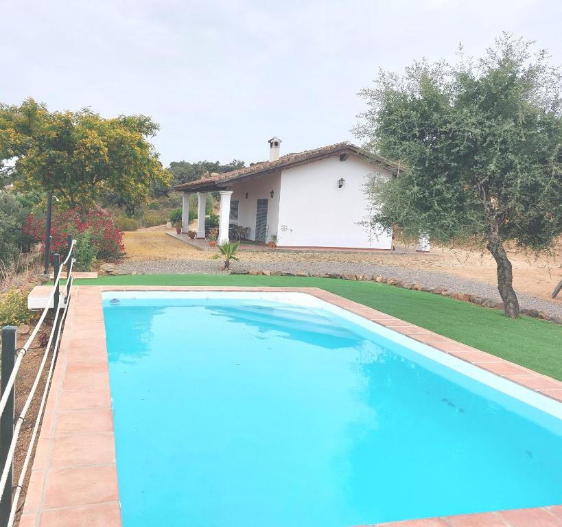 a large blue swimming pool in front of a house at Casa Rural La Aulaga in El Castillo de las Guardas
