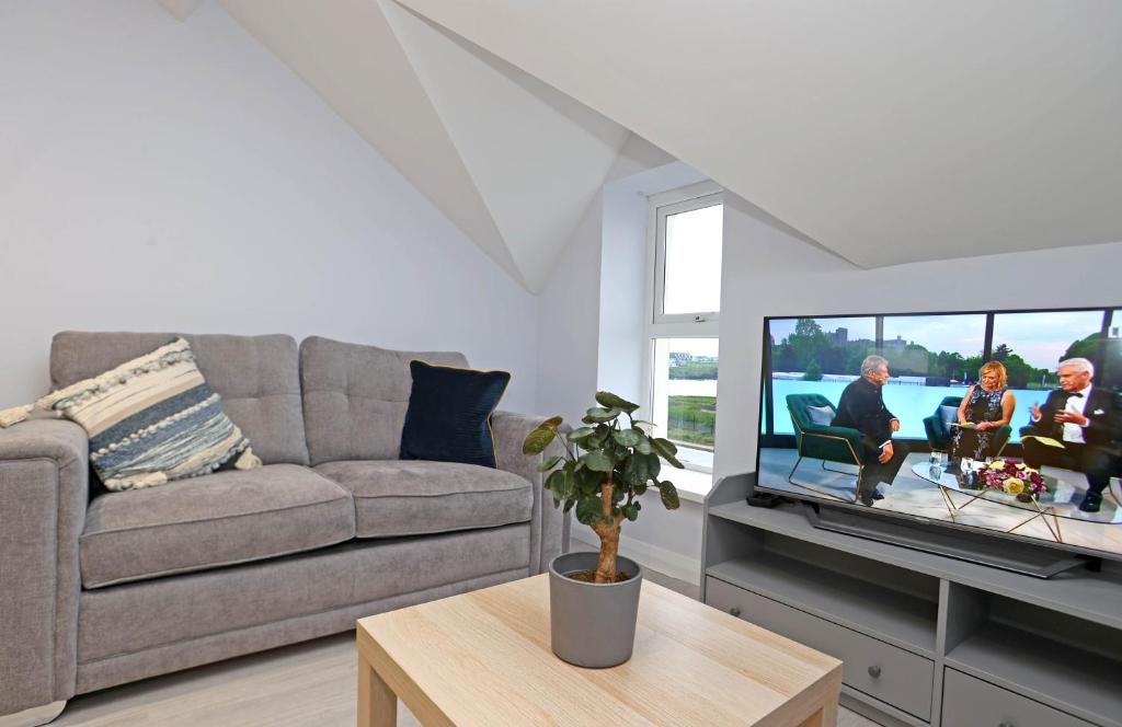 a living room with a couch and a flat screen tv at Entire penthouse apartment with sea views Portrush in Portrush