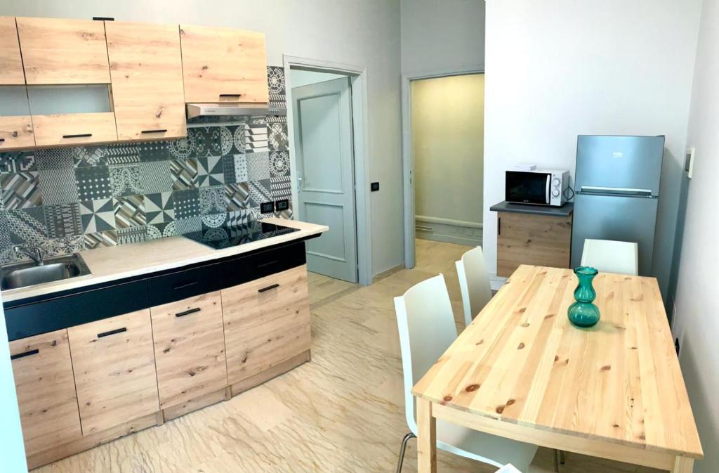 uma cozinha com uma mesa de madeira e uma sala de jantar em Battigia Rimini - Appartamenti Vacanze em Rimini