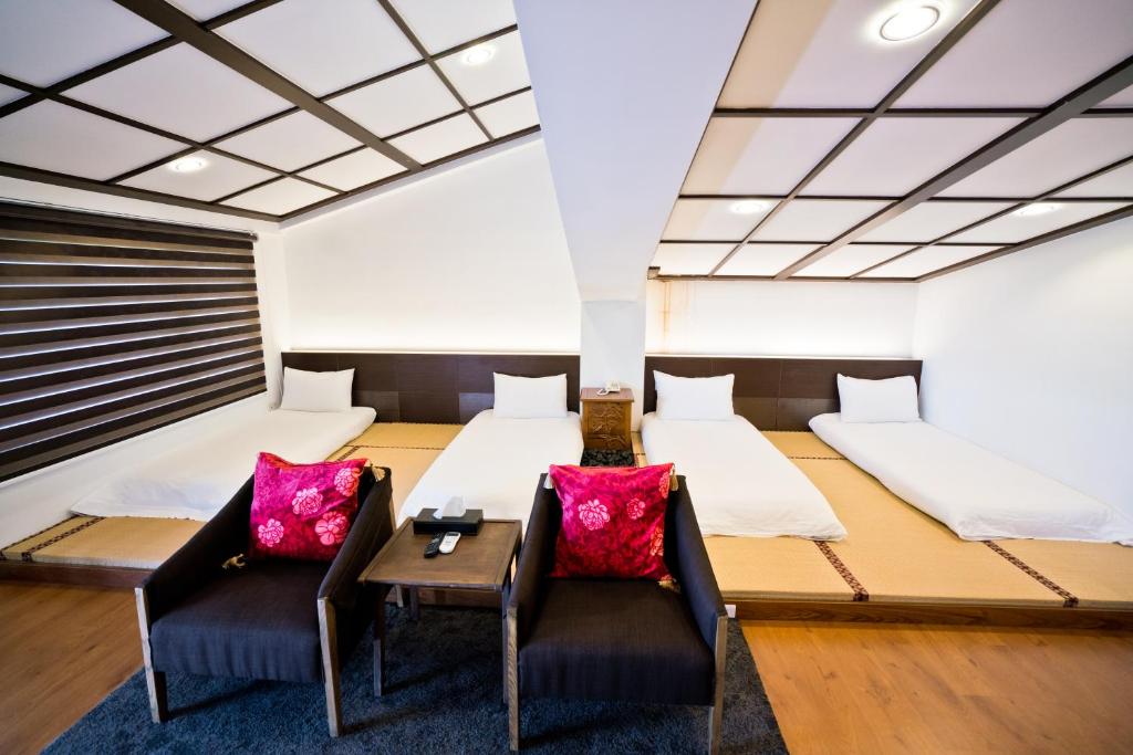 una stanza con due letti, un tavolo e delle sedie di Qing Ping Jn Humanities Hall青萍居人文會館 a Wujie