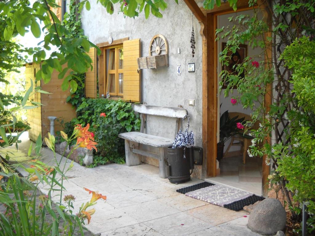 a garden with a bench sitting outside of a building at B&B Artemia in Trento