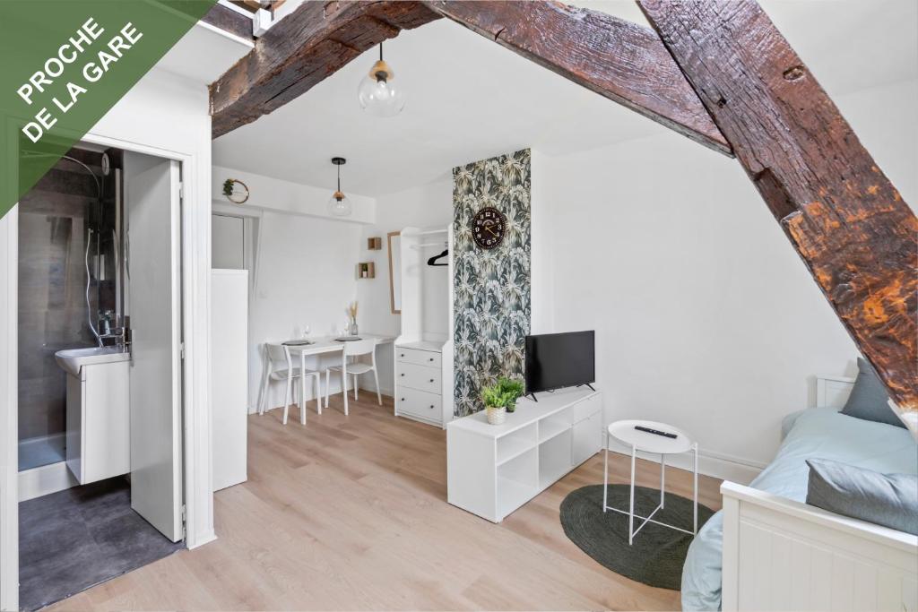 una sala de estar con paredes blancas y vigas de madera. en *Lasuite #3 GREEN*, en Valenciennes