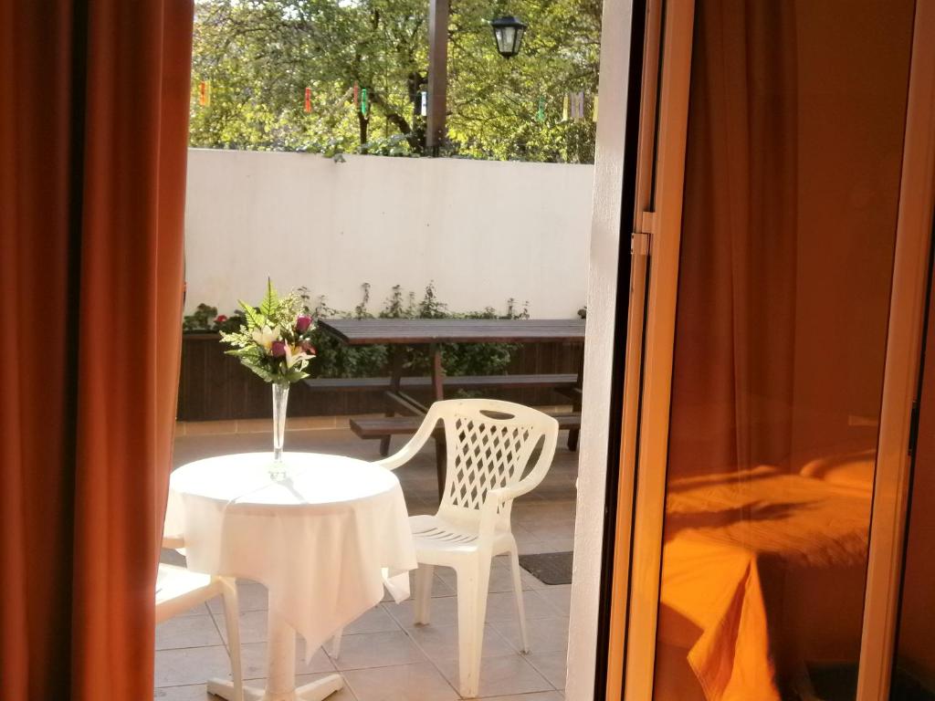 Habitación con mesa, 2 sillas, mesa y ventana. en Pansion Chrisa en Skíathos