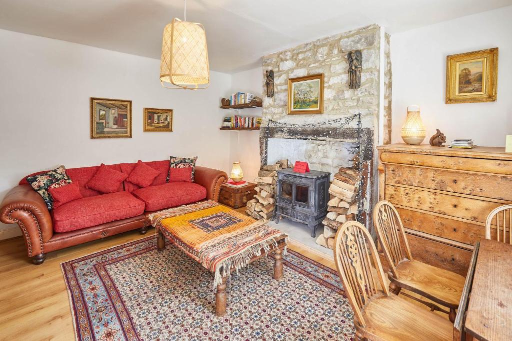 a living room with a red couch and a fireplace at Host & Stay - Elliott Terrace in Wark