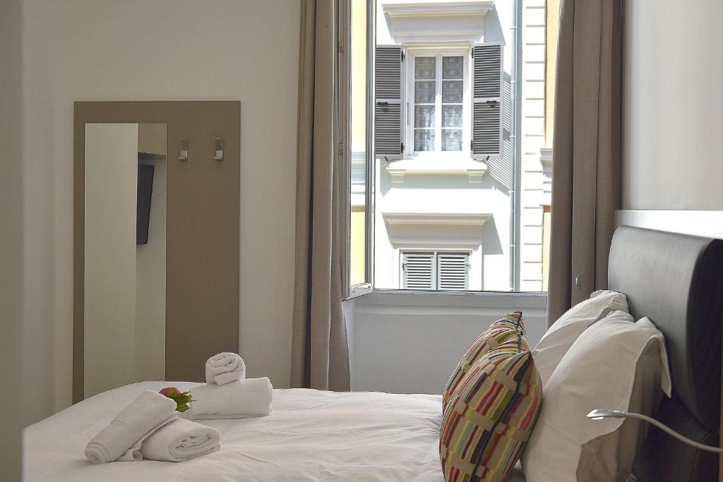 a bedroom with a bed and a large window at Hôtel Continental in Bastia