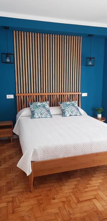 a bedroom with a large bed with a wooden headboard at Casa Maria in Nazaré