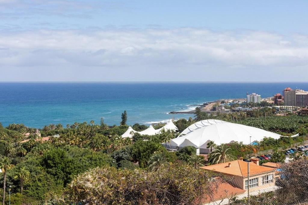 プエルト・デ・ラ・クルスにあるPrime Homes Playa Jardin Studioの海とビーチの景色を望む建物