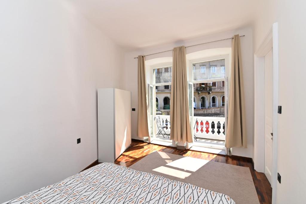 a bedroom with a bed and a large window at Tyson Apartman Rijeka in Rijeka