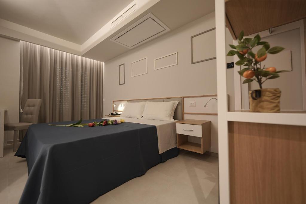 a bedroom with a bed and a table with flowers on it at ELISEO PALACE TROPEA in Tropea